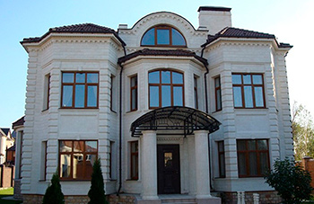 Облицовка фасада двухэтажного коттеджа натуральным белым известняком